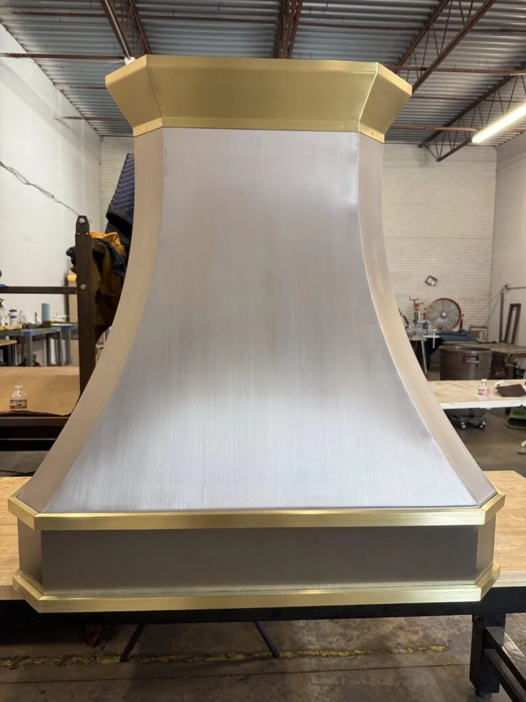 Brushed stainless steel Monarch range hood with brass straps, built for a New Jersey project and photographed at the Texas workshop before delivery — 10 of 12