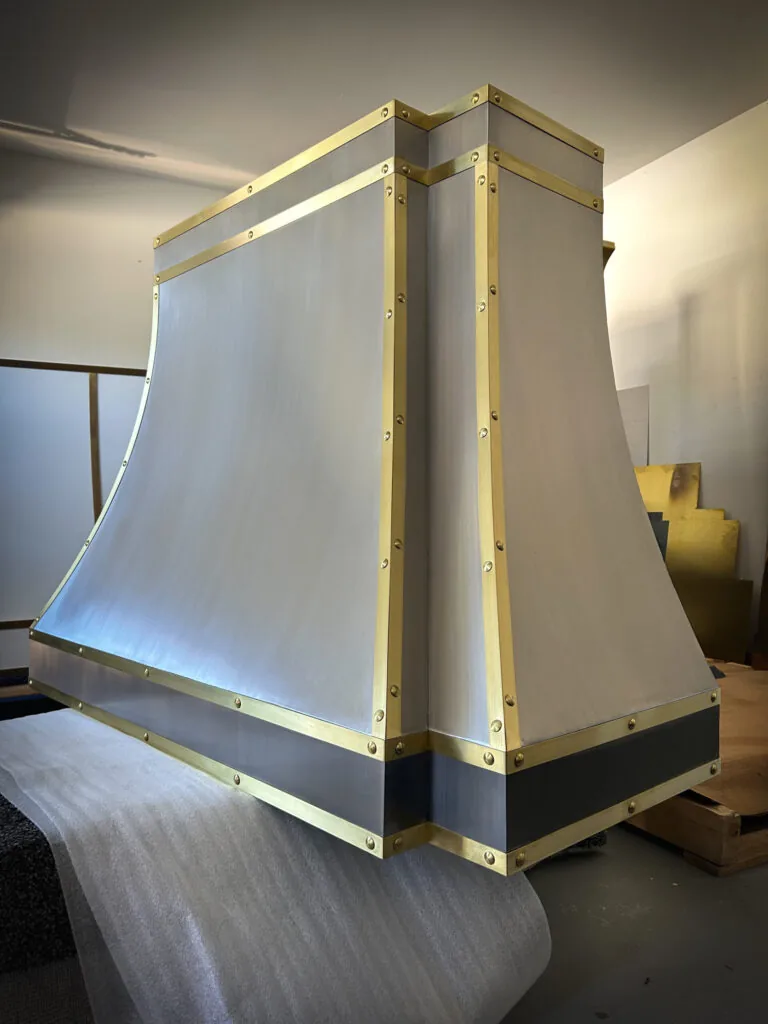 Brushed stainless steel Monarch range hood with brass straps, built for a New Jersey project and photographed at the Texas workshop before delivery — 6 of 12