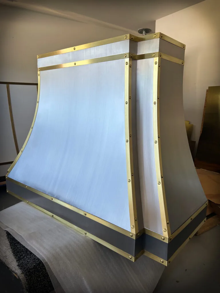 Brushed stainless steel Monarch range hood with brass straps, built for a New Jersey project and photographed at the Texas workshop before delivery — 7 of 12