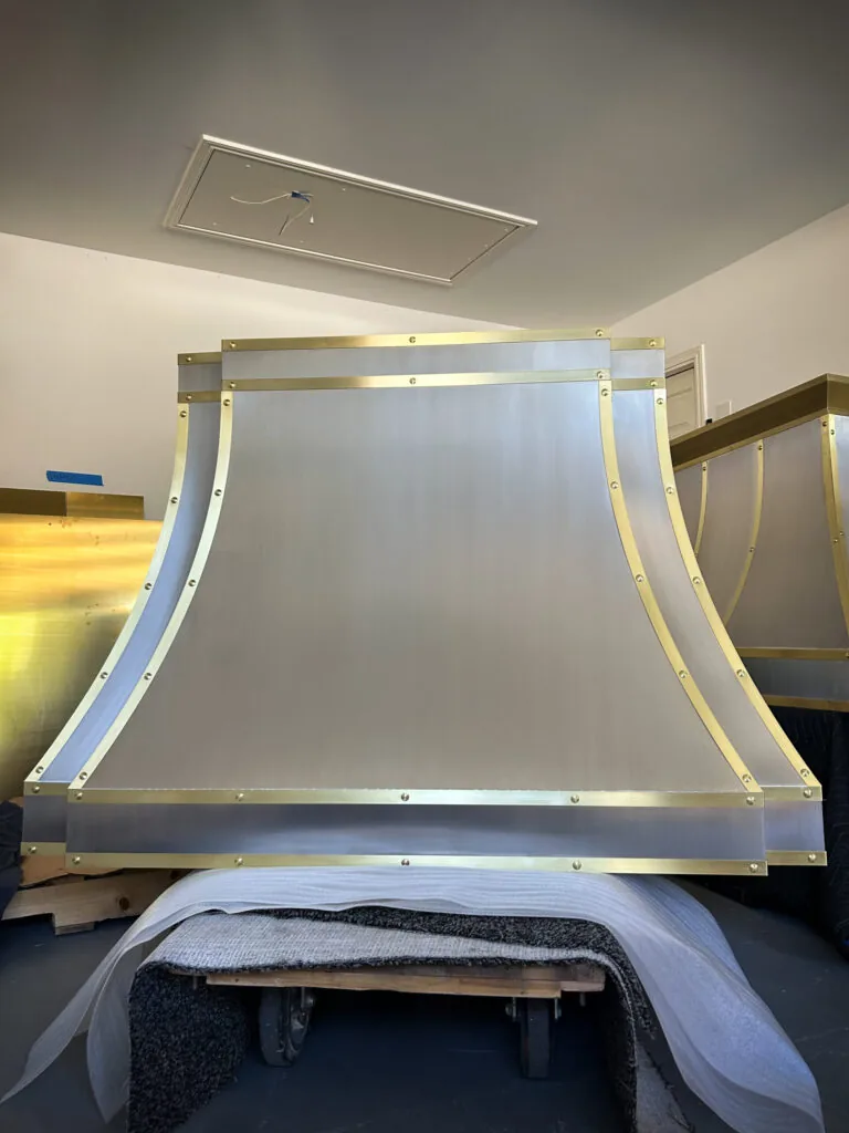 Brushed stainless steel Monarch range hood with brass straps, built for a New Jersey project and photographed at the Texas workshop before delivery — 8 of 12